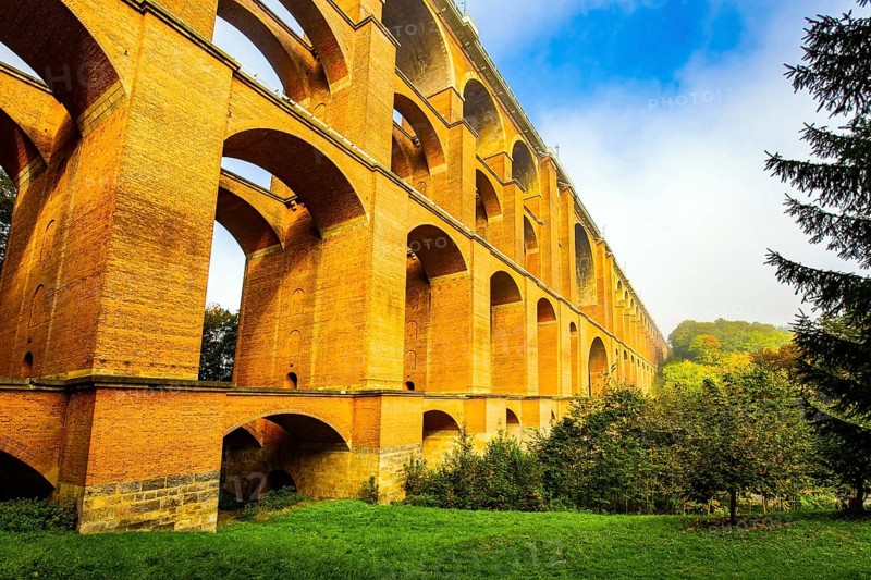 Germany. The Goltzsch Viaduct is the largest red brick viaduct in the world. Sunny cold morning in October. Magnificent huge bridge in a beautiful green park