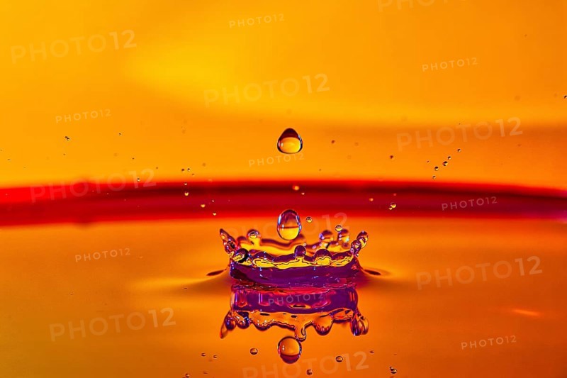 A falling drop of water creates an impressive crown on an orange-coloured surface, high-speed photography, drop photography, Grenzach- Wyhlen, Baden-Württemberg, Germany, Europe