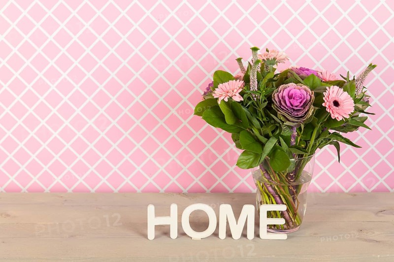 Colorful pink and purple bouquet in glass vase in interior