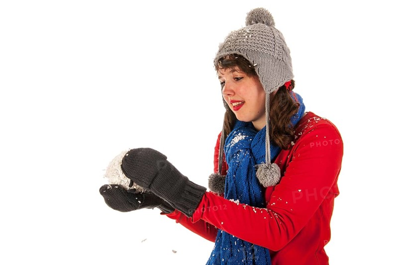 Winter girl in red and blue is throwing snow ball