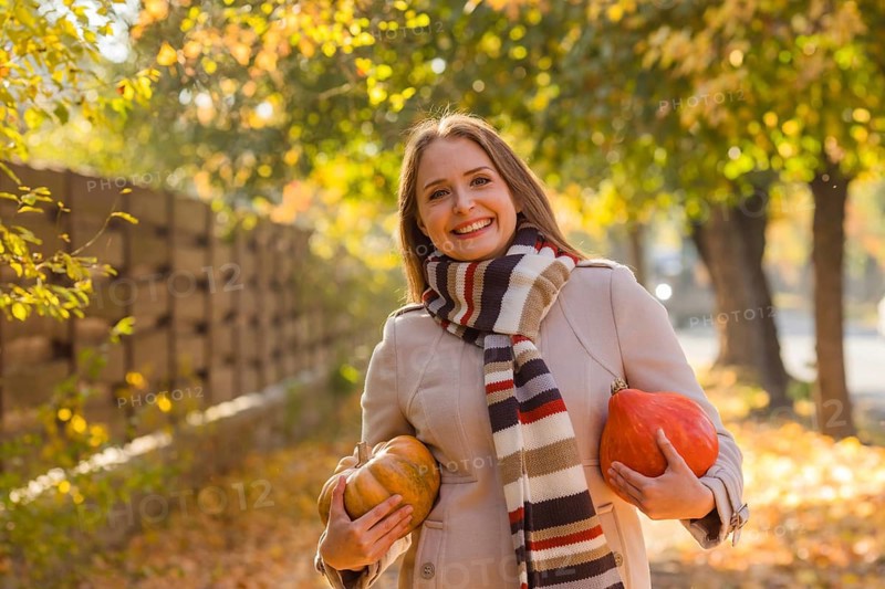 Portrait of happy smile woman with pumpkins in hand. Cozy autumn vibes Halloween, Thanksgiving day