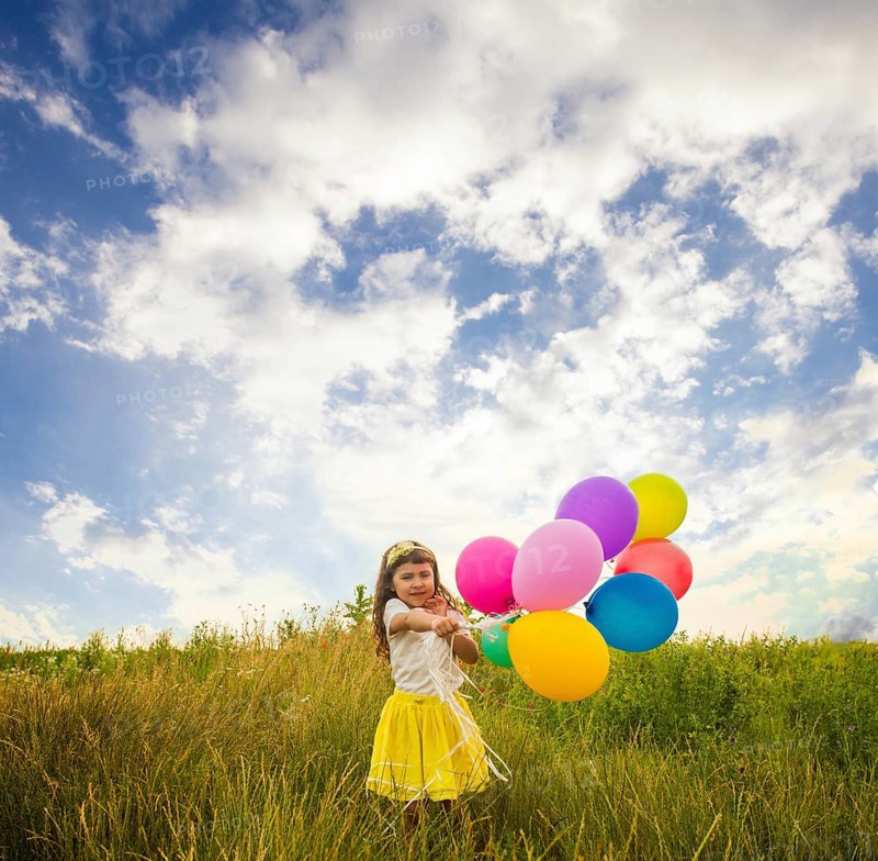 Happy child with colorful toy balloons outdoors