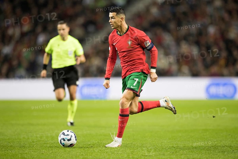 Football match, captain Cristiano RONALDO CR7 Portugal on the ball running towards the left looking forwards, captain's armband, referee Donatas RUMSAS Lithuania trying to keep an eye on the action, sequence 4, Estadio do Dragao, Porto, Portugal, Europe