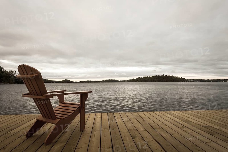 Known as Muskoka or Adirondack chairs sit on a dock at a resort in Muskoka, Ontario, Canada, North America