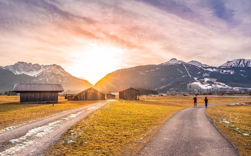 Winter landscape with mountain village in the Austrian Alps, wooden barns and country roads, at sunset. Perfect decor for an evening run
