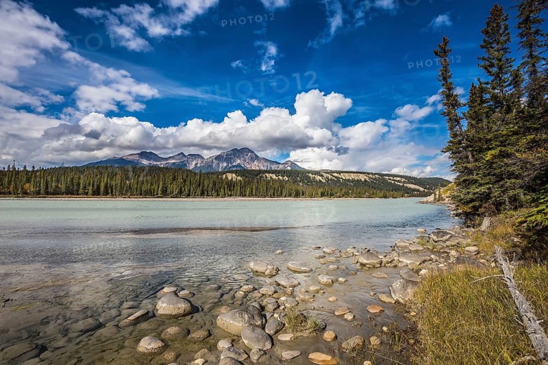 Evergreen forests and snow-capped Rocky Mountains of Canada. Beneaped Medicine Lake in the fall