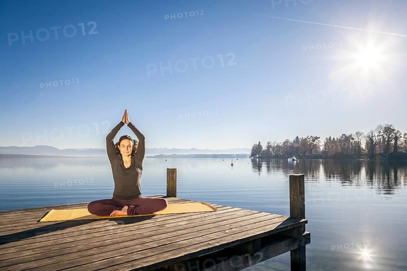 An image of a pretty woman doing yoga at the lake