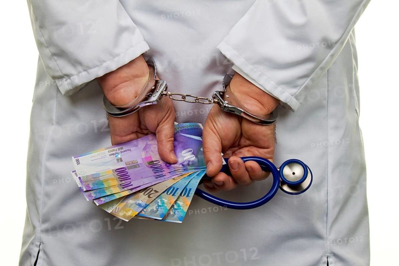 A doctor with Swiss franc banknotes and handcuffs, Austria, Europe