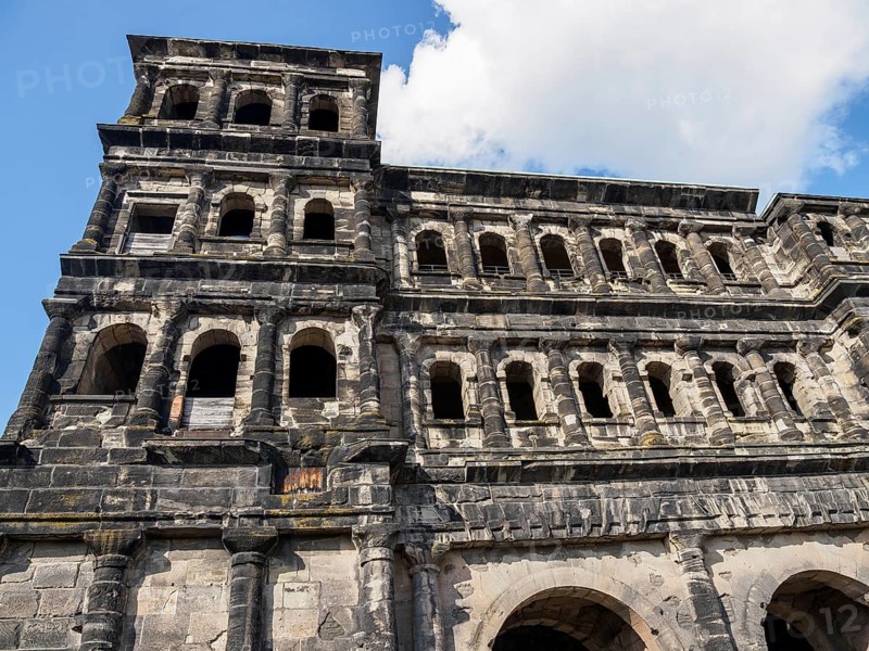 Historic stone architecture with many windows under a blue, cloudy sky, Trier, Germany, Europe