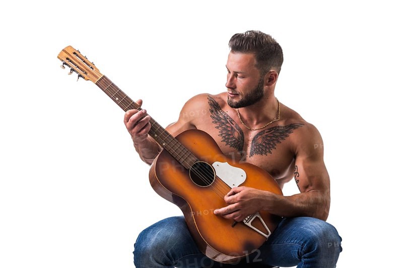 Portrait of muscular man with tattoo playing guitar. Isolated on white background. Full length shot