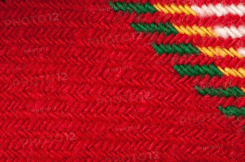 Handmade knit green and red background. Close up structure of the yarn. Christmas colors