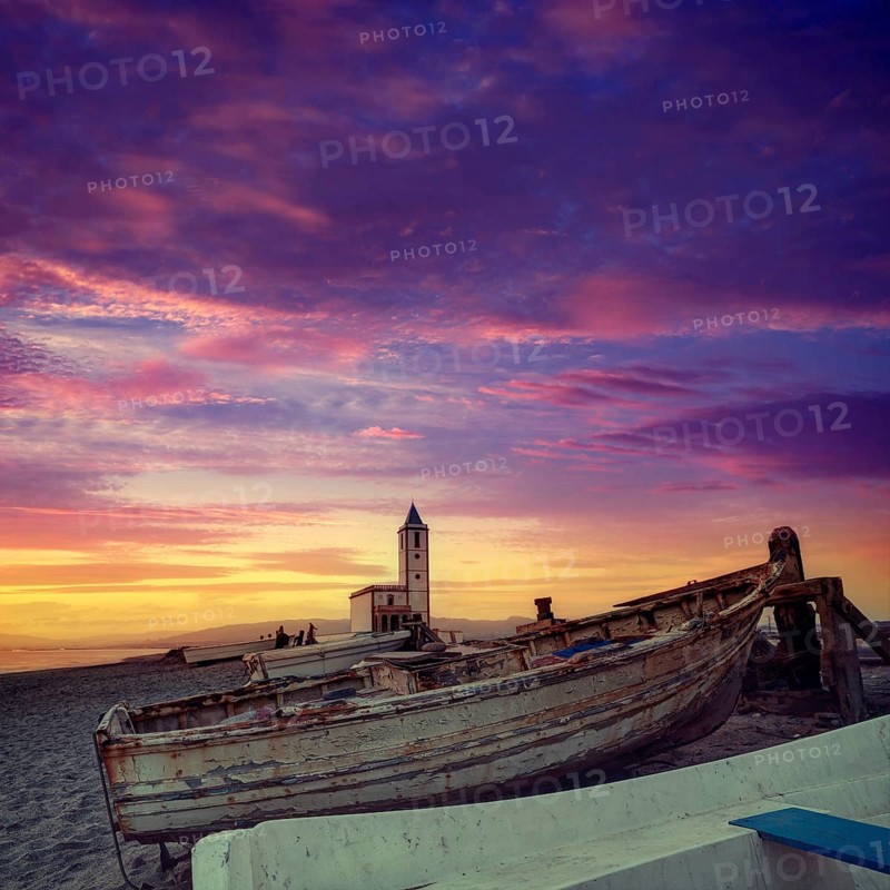 Cabo de Gata in Almeria at San Miguel Beach and Salinas church with stranded boats at sunset