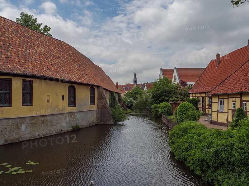 Historic half-timbered houses along a quiet river in dense vegetation, steinfurt, münsterland, germany
