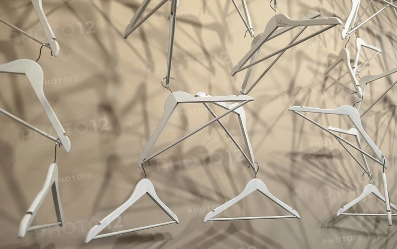 Empty wooden clothes hangers casting deep shadows. Real coat hanger wood pattern. Abstract fashion concept