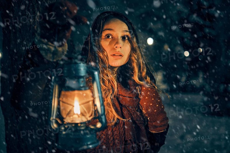 Young girl with lantern in winter forest fairy tale, book cover, christmas time