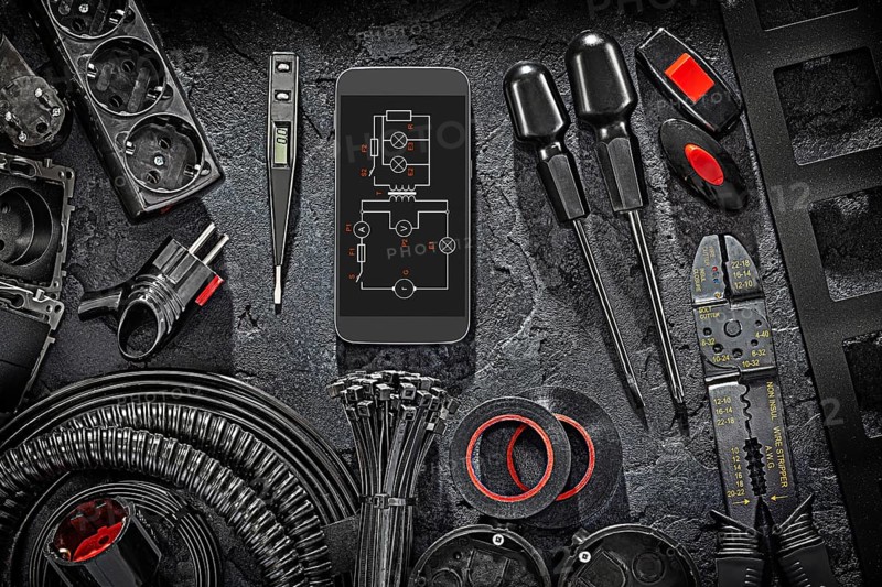 Electric Tools Set With Blueprint On Smartphone Display On Black Stone Background