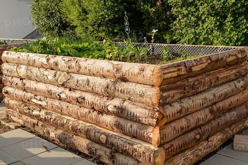 Planted raised bed made from rustic tree trunks