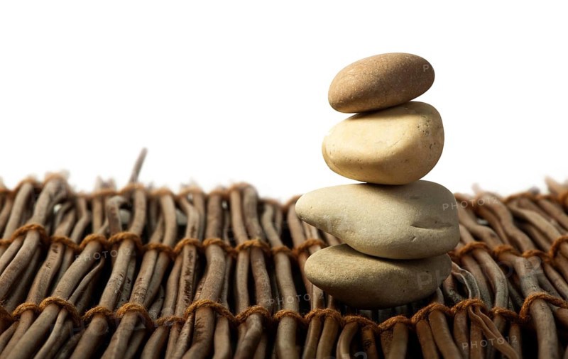 Stacked stones on wooden base. White isolated