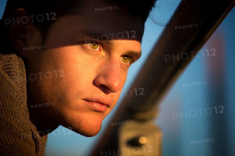 Headshot of handsome young man, lit by sunset light