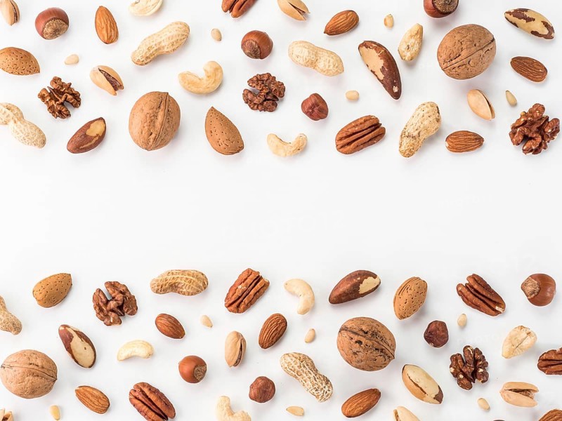 Pattern of nuts mix with copy space. Various nuts isolated on white. Pecan, macadamia, brazil nut, walnut, almonds, hazelnuts, pistachios, cashews, peanuts, pine nuts. Top view or flat-lay. Copy space