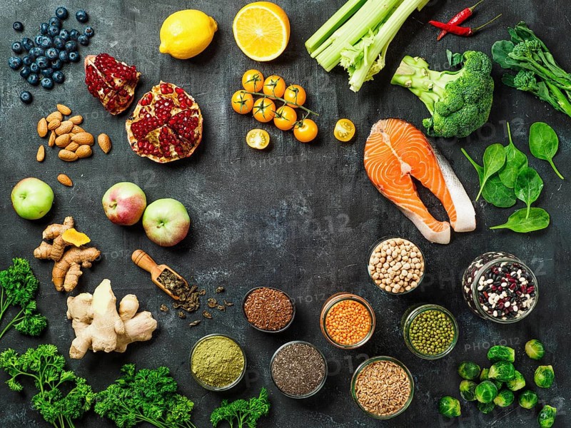 Clean Eating concept with copy space in center. Selection food ingredients for Clean Eating on dark background. Top view or flat lay