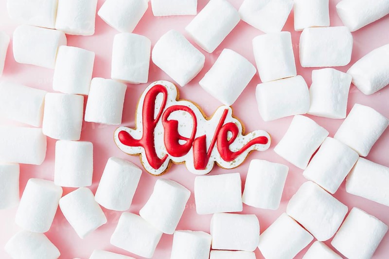 Gingerbread cookies love with white marshmallow. Valentine card. Pink background.