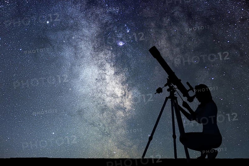 Girl looking at the stars with telescope. Milky Way galaxy