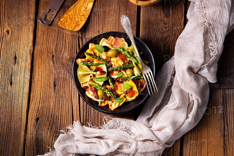 Pasta salad with green asparagus, olives and Parma ham