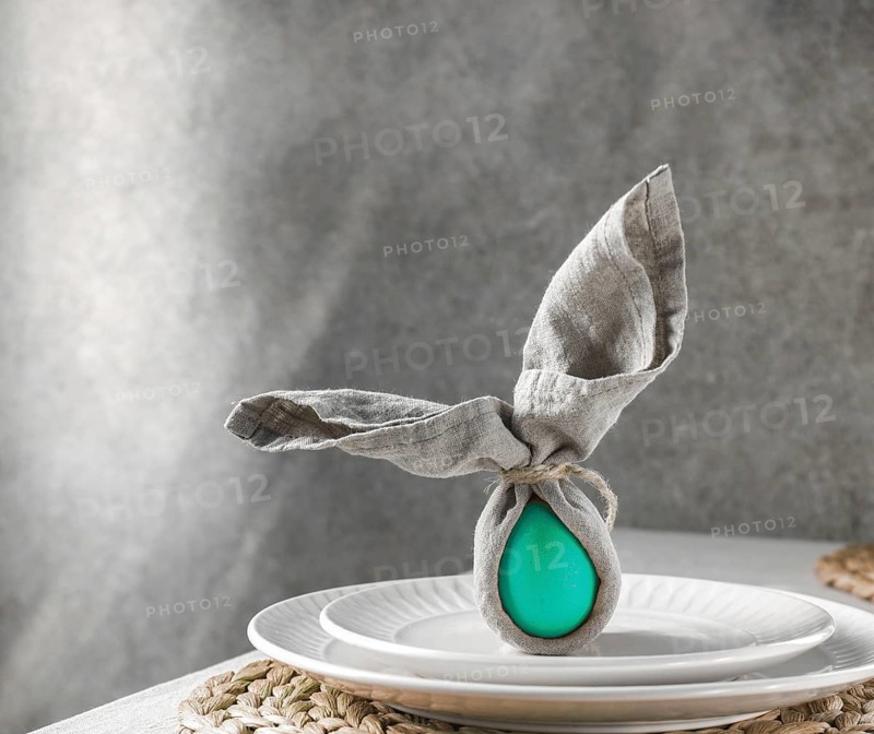 Food, Food, Festive Easter table setting. Funny Easter bunny made of green egg and linen napkin on plate. Gray background
