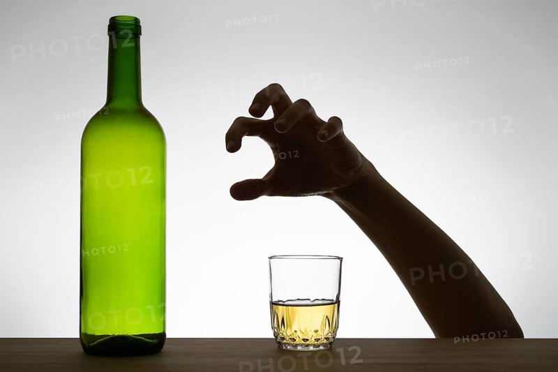 Silhouette of a hand reaching for a glass of wine