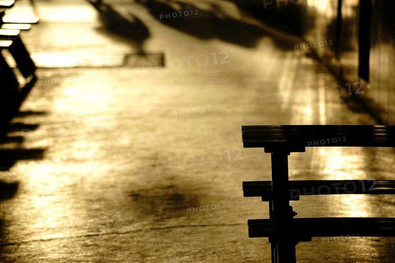 Gold-coloured light reflections in a corridor or passageway of a shopping street with shadows and outlines
