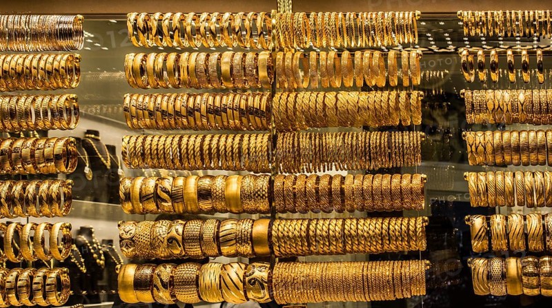Shop display of dozens of golden bracelets and bangles
