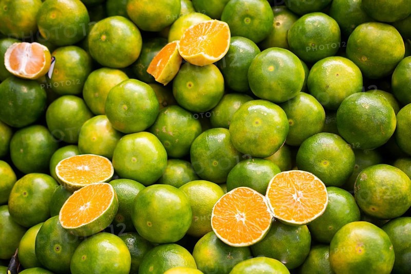 Freshly picked green tangerines mandarines, clementines, as Citrus fruit background