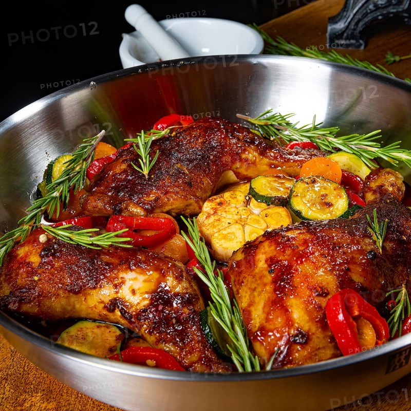 Roasted chicken legs with various vegetables and spices