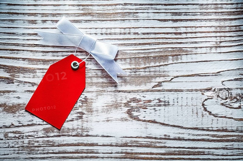 Red shopping tag on vintage wooden board