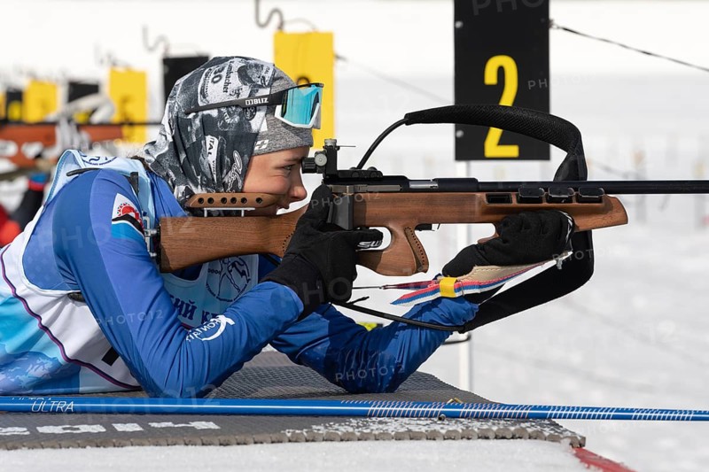 Sportswoman biathlete aiming, rifle shooting in prone position. Biathlete Arina Soldatova Kamchatka Peninsula in shooting range. Junior biathlon competitions East Cup. Kamchatka, Russia, Apr 13, 2019, Europe