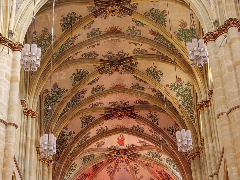 The interior of a church with ornate frescoes on the vaulted ceiling and decorative Gothic style elements, trier, germany