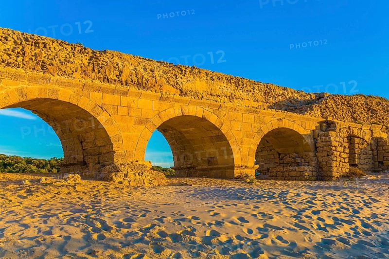 Stunning sunset on the Mediterranean coast in Israel. Well-preserved aqueduct, built in Caesarea at the beginning of the Byzantine period. Concept of active, ecological and historical tourism