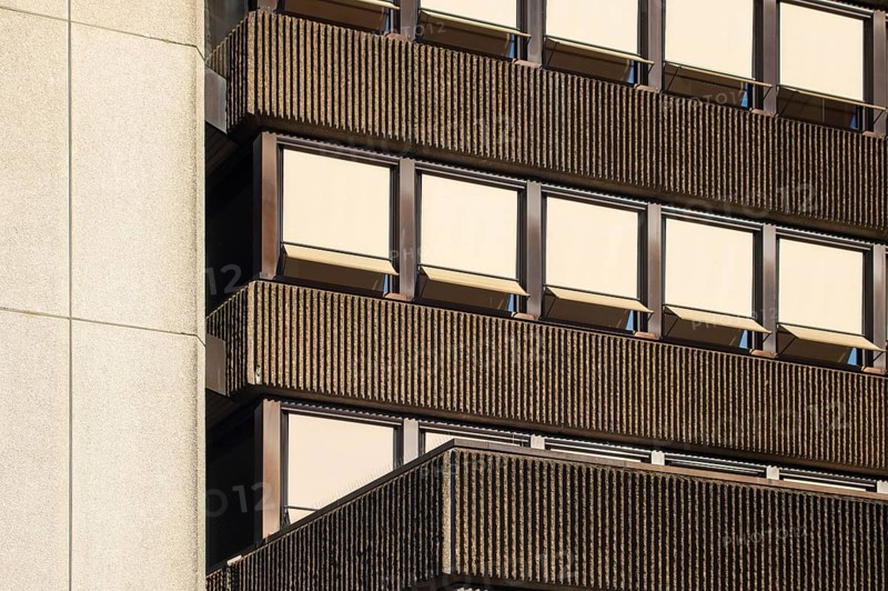 Sunlight illuminating a modernist building facade with ribbed concrete and rows of windows with sunshades, Borken, NRW, Germany, Europe