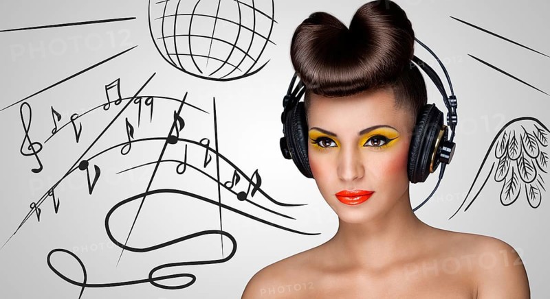 Clubbing fashionable girl in nightclub with big vintage headphones on grey sketchy background of a disco ball and flowing music notes
