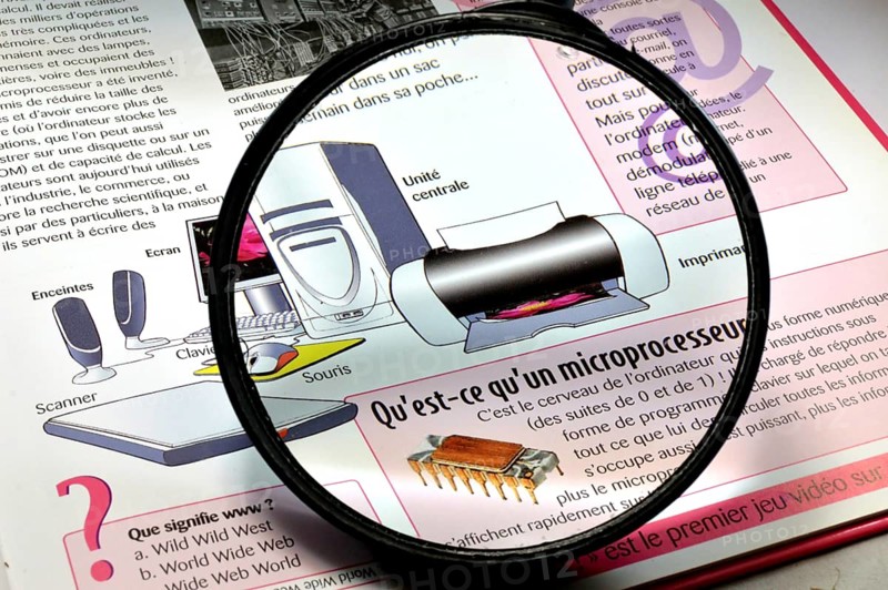 Magnifying glass on a book of explanations on the invention of the computer