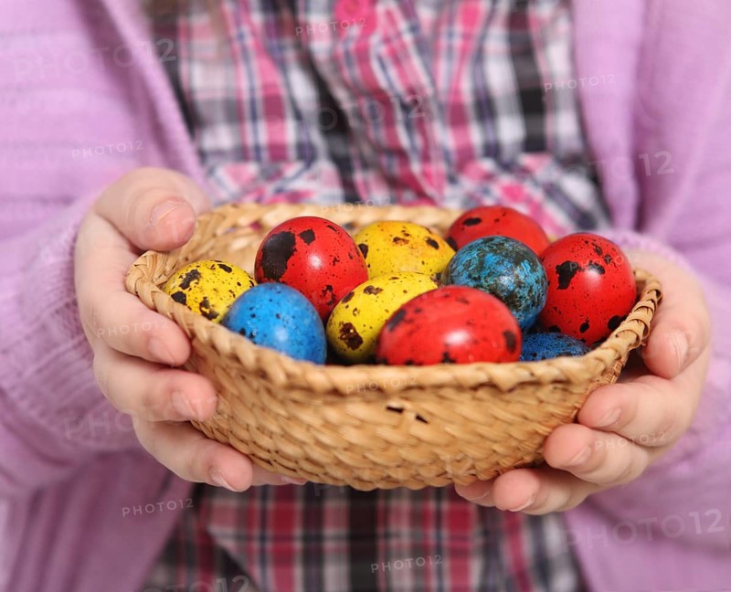 Cute little girl holding basket with easter eggs. Close up
