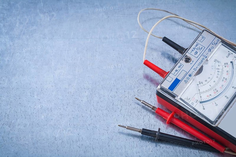 Electrician's instrument of measurement on scratched metallic background construction concept