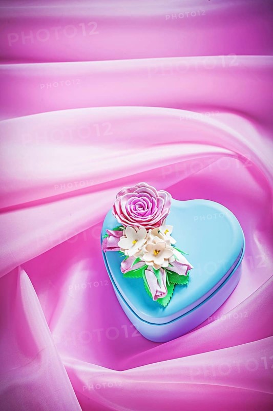 Blue gift box with present on pink fabric background holidays concept