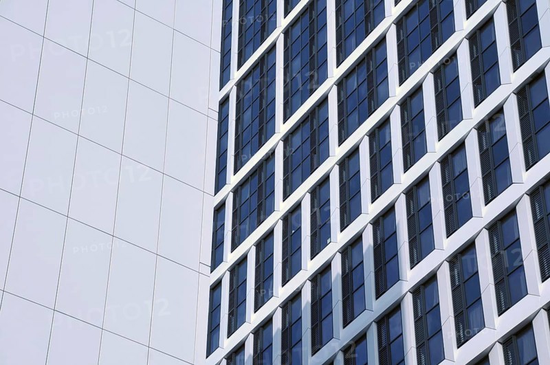 Close up detail of tall high rose modern apartment buildings with white cladding and dark windows