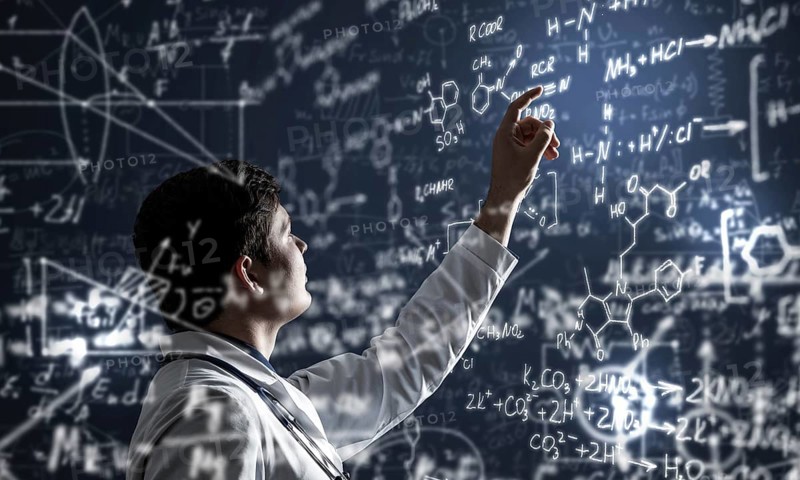 Young scientist works with scientific formulas. mixed media