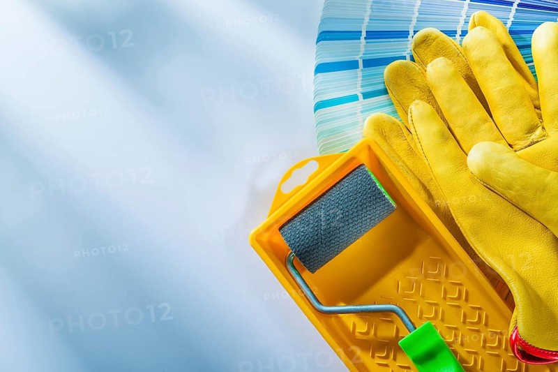 Color palette paint roller tray safety gloves on white surface