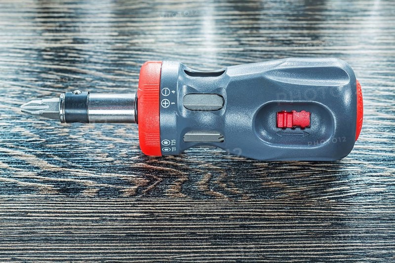 Screwdriver on wooden board top view