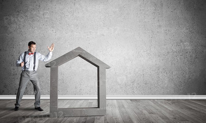 Stone home silhouette in empty room as symbol for real estate insurance