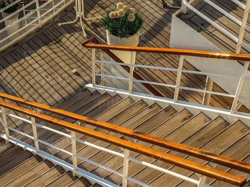 Wooden staircase with railing on a ship deck and a decorative potted plant with flowers, stockholm, baltic sea, sweden, scandinavia